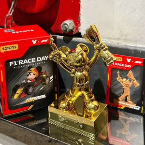 Topolino dorato accanto alla confezione della serie F1
